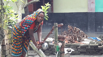 woman at the water pump in Hogladanga, Bangladesh